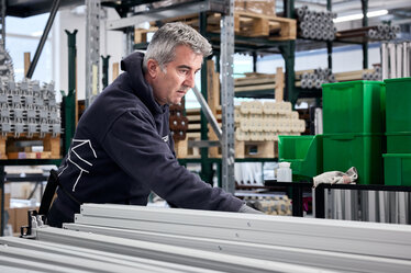 Arbeiter baut die Aluminiumbeine eines Ecotent-Faltzelts von Hand zusammen