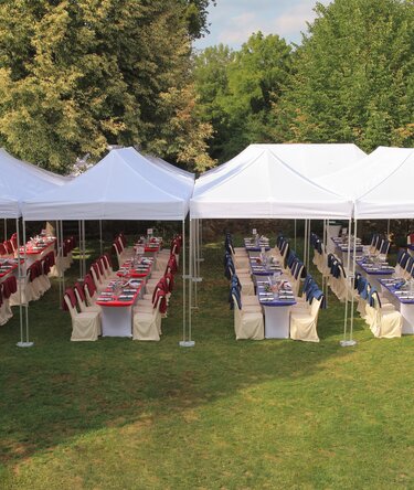 Sistema di gazebo bianchi 8x4 per un catering di un matrimonio su un prato organizzato sa Ringhotel Woerlitz