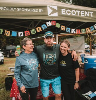 Auf einem Sportevent steht ein oliv-farbener, bedruckter Faltpavillon Serie E1 der Größe 3 x 3 Meter von Human Powered Movement.