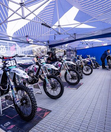 Rennmotorräder des Cat Moto Motocross Teams unter Ecotent Faltpavillons.