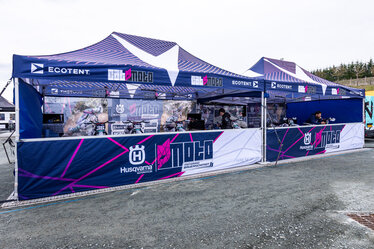 Cat Moto Motocross Team with two Ecotent pop-up gazebos at a European race paddock.